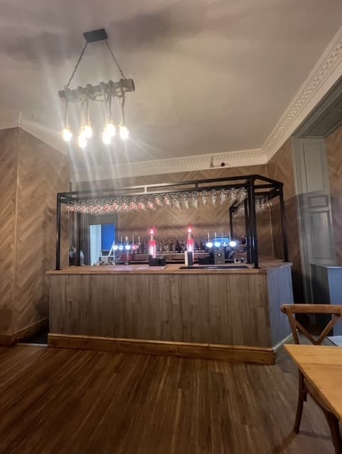 Bespoke timber bar counter and back-bar fit-out for a hospitality venue, with optics display, glass rack and herringbone timber wall panelling